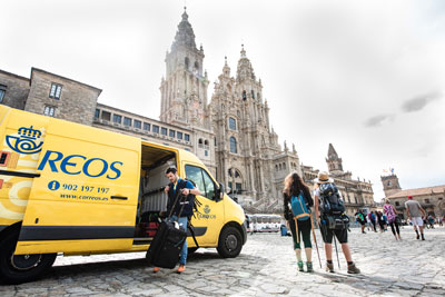 Correos bag transport van in Santiago and pilgrims waiting for their bags. 